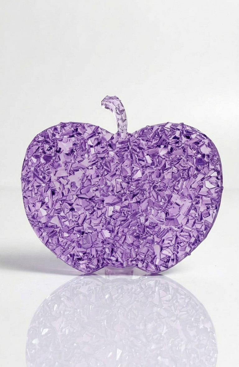 A person holding the flexible apple silicone mold to show its thickness, scale relative to a human hand, and product durability.