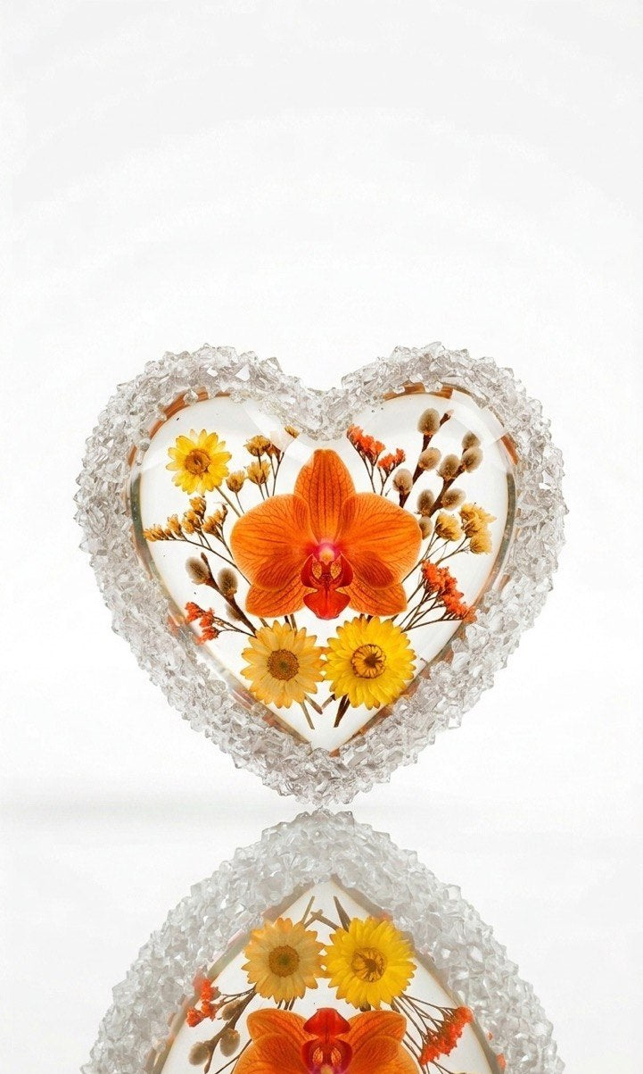 Clear silicone heart mold holding dried flowers like a central orchid, surrounded by the rough texture of the crystal edge, showcasing a floral resin project.
